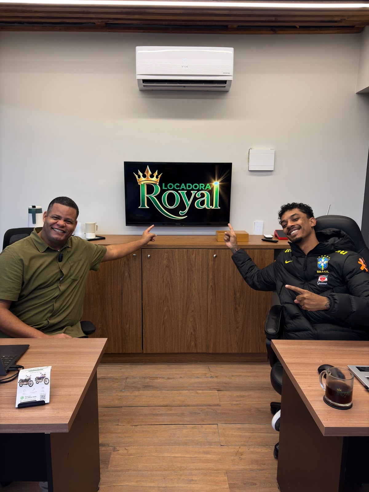 Equipe da Royal no escritório, junto à marca da locadora